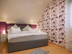 a bedroom with a large bed with a floral wallpaper at Ferienwohnung Eva Maria in Mahlberg +21 photos