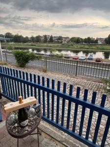 a bottle of wine sitting on a chair next to a fence at Ferienwohnung Blaue Maus in Meißen +4 photos