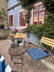 a chair and a table and a bench in front of a house at Ferienwohnung Blaue Maus in Meißen