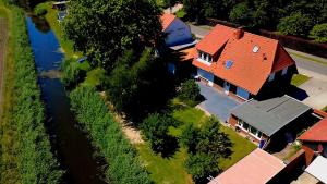 a house with a red roof and a river at Ferienhaus Timeout in Friedrichskoog