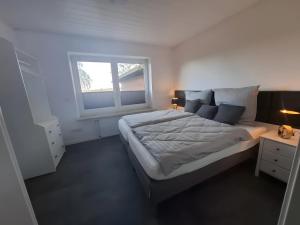 a bedroom with a large bed and a window at Ferienhaus Timeout in Friedrichskoog