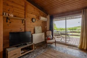 a living room with a television and a window at La Voûte Des Oliviers in Bessas
