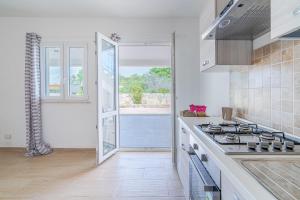 a kitchen with a stove top oven next to a window at Villa Ohana in Syracuse