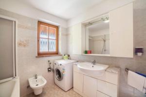 a bathroom with a washing machine and a sink at Hoferhof Apartement Bergspitze in Schenna
