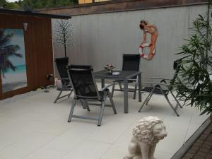 a patio with a table and chairs and a girl on the wall at Ferienwohnung Sprang in Steinen +2 photos