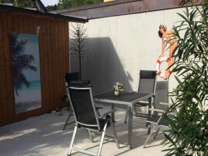 a patio with a table and chairs and a painting of a woman at Ferienwohnung Sprang in Steinen
