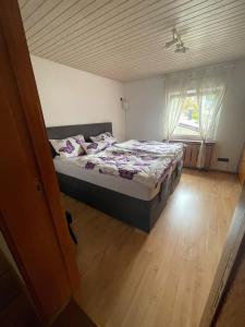a bedroom with a bed and a large window at Ferienwohnung Sprang in Steinen