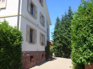 a white building with trees in front of it at Ferienwohnung Sprang in Steinen
