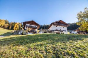 a large house on top of a grassy hill at Hoferhof Apartement Bergspitze in Schenna