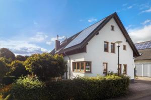 a white house with solar panels on the roof at Ferienwohnung Quinkert in Eslohe