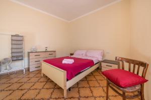 a bedroom with a bed and a chair at Casa di Stefania in Fluminimaggiore