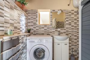 a bathroom with a washing machine and a sink at Casa di Stefania in Fluminimaggiore