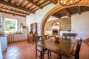 a kitchen and dining room with a wooden table and chairs at Podere Montorgialino in Murlo