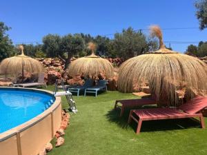 a resort with a swimming pool andiki umbrellas and chairs at Casa Frango in Moncarapacho