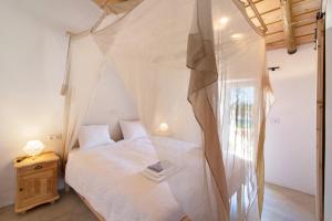 a bedroom with a bed with a mosquito net at Casa Frango in Moncarapacho +14 photos