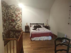 a bedroom with a bed and a staircase with a stair railing at Au P'tit Venton - Maison Écologique in La Jaille-Yvon