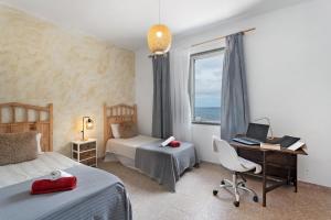 a bedroom with two beds and a desk with a laptop at House in Anaga in Almáciga