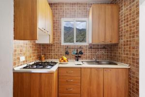 a kitchen with wooden cabinets and a sink and a window at House in Anaga in Almáciga +21 photos