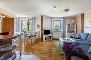 a living room with a blue couch and a table at Haevn-Erholung, Fewo Deichblick in Reußenköge