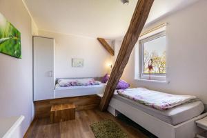 a small room with two beds and a window at Haevn-Erholung, Fewo Deichblick in Reußenköge