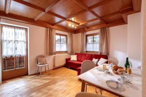 a living room with a table and a red couch at Zeunerhof in Fügen