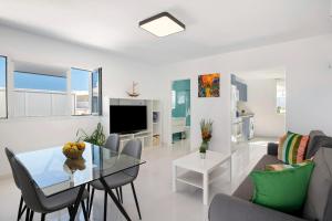 a living room with a table and chairs and a television at Tritón 6 in La Santa