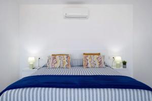 a white bedroom with a blue bed with two pillows at Tritón 6 in La Santa