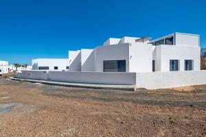 a white building on top of a dirt lot at Tritón 6 in La Santa