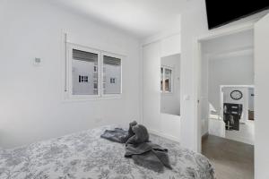 a white bedroom with a stuffed animal sitting on a bed at Villa Violeta in Costa Del Silencio +23 photos