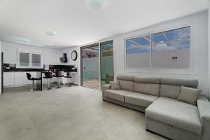 a living room with a couch and a kitchen at Villa Violeta in Costa Del Silencio