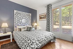 a bedroom with a black and white bed and a window at Bastide Lou Pèbre D’aï in La Roquebrussanne +48 photos