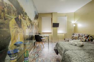 a room with a bed and a painting on the wall at Triana Historic Center in Seville +14 photos