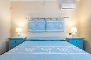 a bedroom with a blue bed and two blue night stands at Villa Gle in Quartu SantʼElena +22 photos