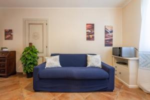 a blue couch in a living room with a microwave at Villa Gle in Quartu SantʼElena