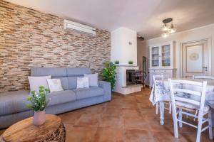 a living room with a couch and a brick wall at Villa Gle in Quartu SantʼElena