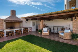 an outdoor patio with a fireplace and an outdoor kitchen at Villa Gle in Quartu SantʼElena