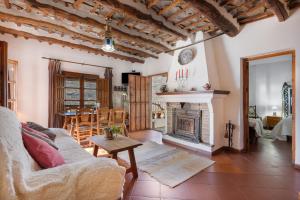 a living room with a couch and a fireplace at Casa de la Fuente in Bubión