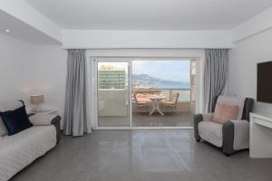 a living room with a couch and chairs and a balcony at Penthouse with private pool in Málaga