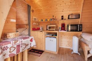 a log cabin kitchen with a table and a refrigerator at Cabane Perce Neige - Gavarnie in Gèdre