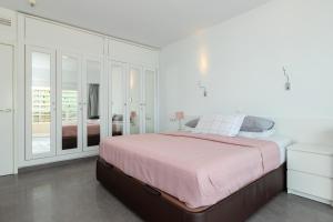 a white bedroom with a large bed with pink sheets at Penthouse with private pool in Málaga +21 photos