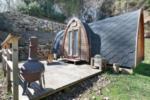 a small house with a deck and a stove at Cabane Perce Neige - Gavarnie in Gèdre +14 photos