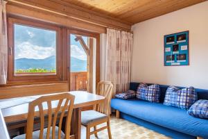 a living room with a blue couch and a table at Gamperhof Apartment Planet in Collepietra