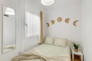 a white bedroom with a bed and a mirror at Odelaria Home in Ingenio