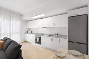 a kitchen with white cabinets and a black refrigerator at Odelaria Home in Ingenio +10 photos