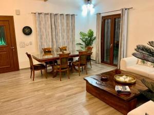 a living room with a dining room table and chairs at Villa Logas Hill in Peroulades