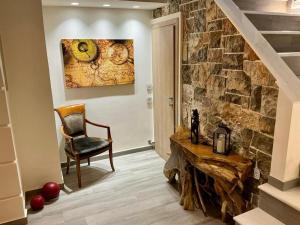 a living room with a stone wall and a chair at Villa Logas Hill in Peroulades
