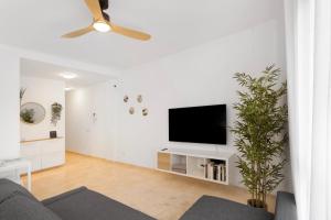 a living room with a flat screen tv on a white wall at Odelaria Home in Ingenio