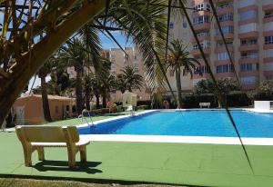 a swimming pool with a bench next to a building at Front Americano in Torrox Costa +6 photos