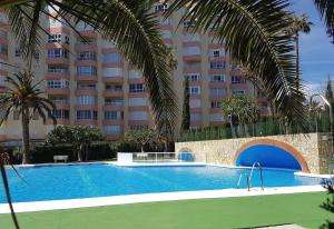 a swimming pool in front of a large building at Front Americano in Torrox Costa
