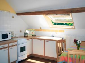 a small kitchen with white cabinets and a window at La Grange in Doussard